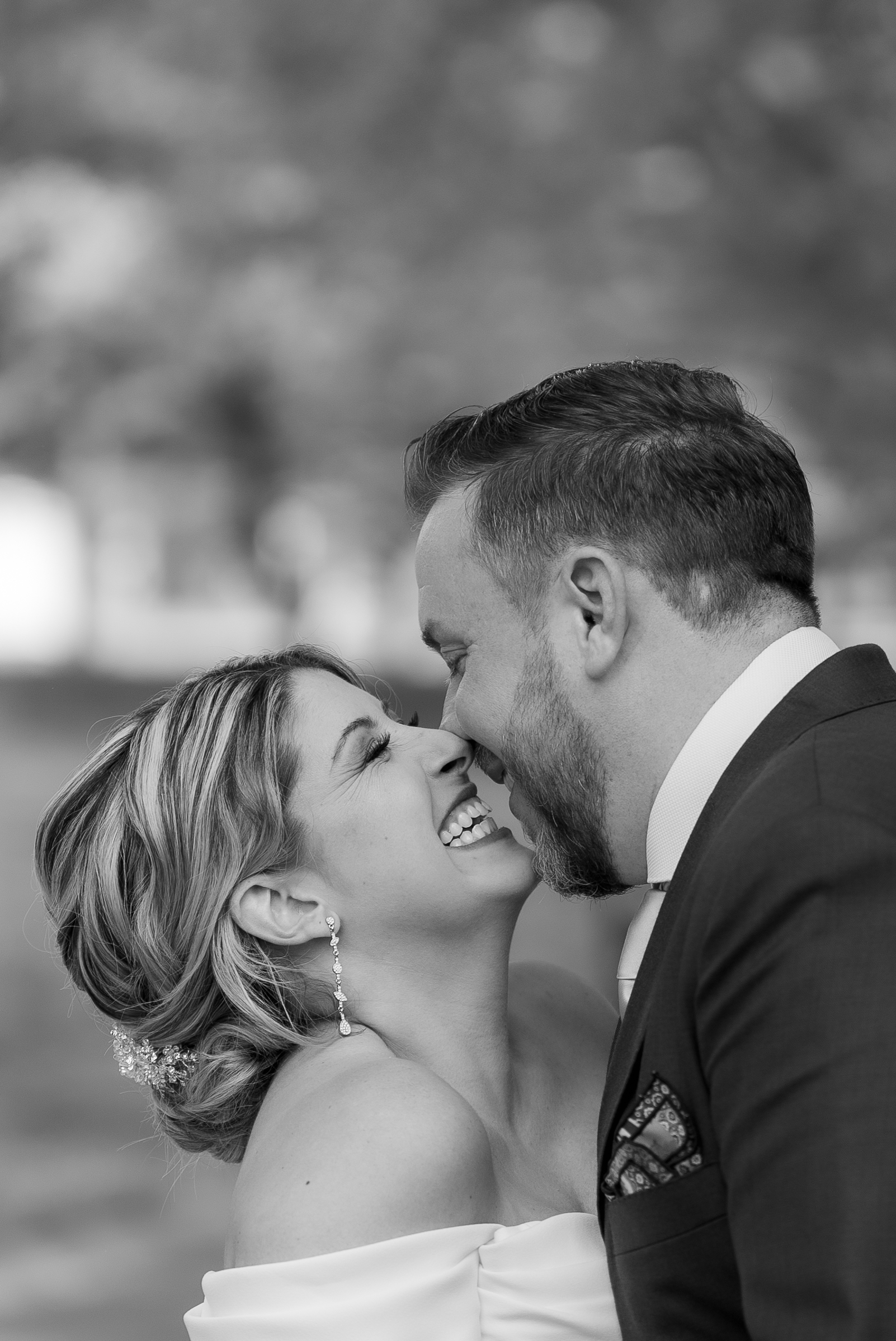 bride and groom closeup laughing in black and white