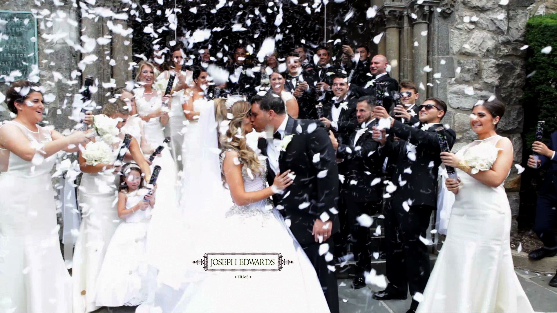 bride and groom kissing in front of a church with confetti everywhere.